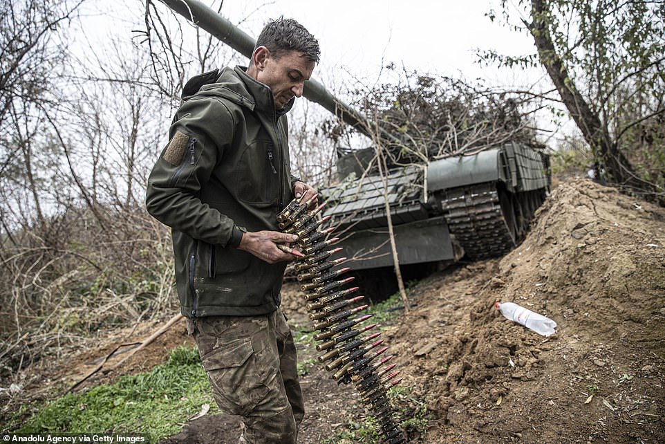 A Ukrainian gunner loads high-calibre rounds into the main gun mounted on top of his tank as he prepared to advance in the Kherson region after Russia said it was retreating